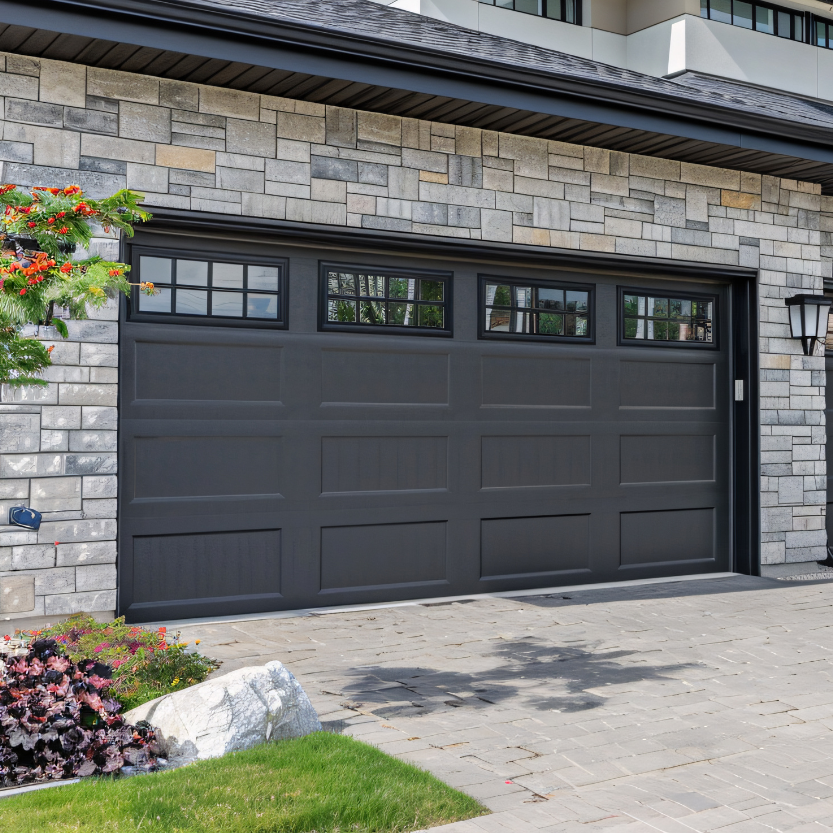 Picture of a house with a newly replaced dark garage door.